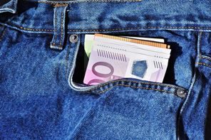 In einer Jeanstasche stecken Geldscheine.