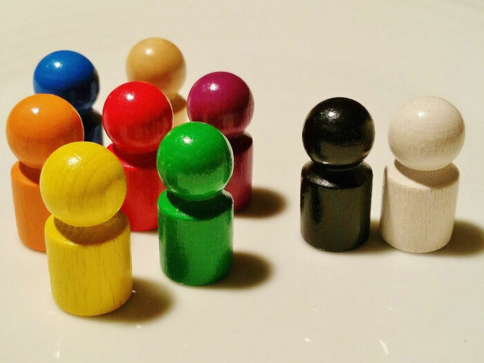 Verschiedenfarbige Spielfiguren auf weißem Grund